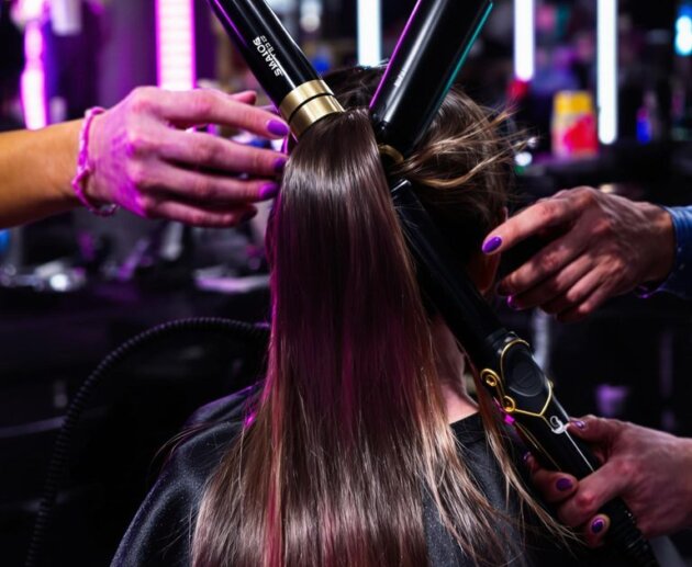 Hairstylist using vibrant professional tools in a modern salon setting.