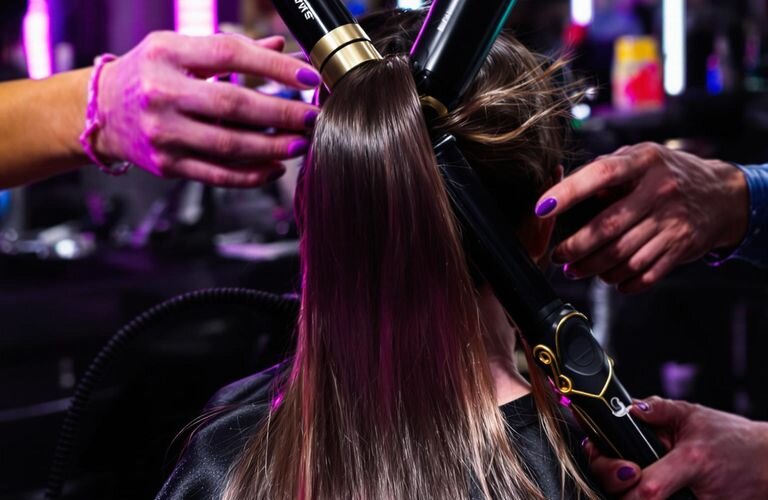Hairstylist using vibrant professional tools in a modern salon setting.